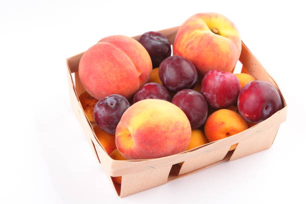 персики, абрикосы и сливы в корзине, изолированной на белом фоне - nectarine стоковые фото и изображения