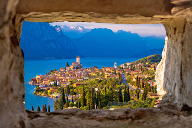 Malcesine and Lago di Garda aerial view through stone window, Veneto region of Italy Malcesine and Lago di Garda aerial view through stone window, Veneto region of Italy lake garda photos stock pictures, royalty-free photos & images