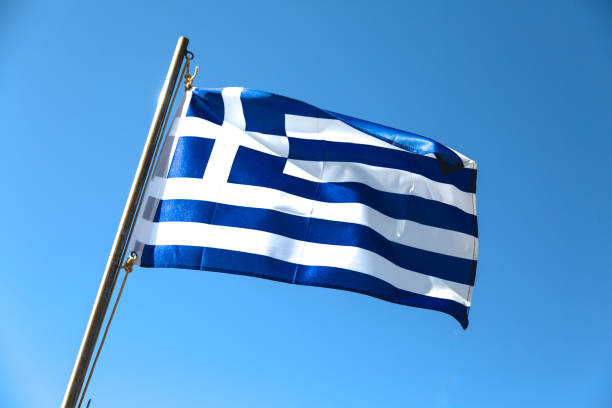 istock Green nation flag waving on blue sky background 819211670