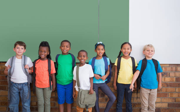istock Cute pupils smiling at camera in classroom 819229314