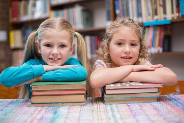 istock Cute pupils smiling at camera in library 819233868