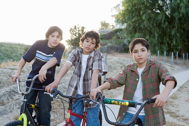 grupo de niños en bicicletas - three boys fotografías e imágenes de stock