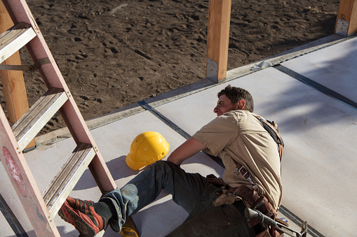 Carpenter building a home at construction site.  Falling off ladder. Injured leg.