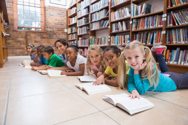 Female teachers teaching students in library at school
