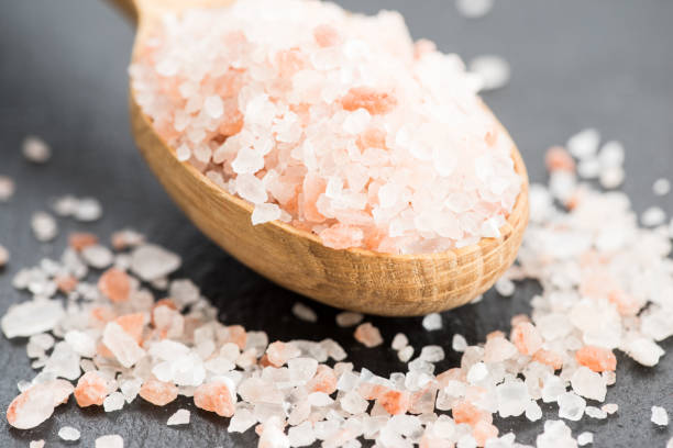 himalayan pink crystal salt. spoon of pink himalayan salt on slate plate - salt crystal spoon food imagens e fotografias de stock