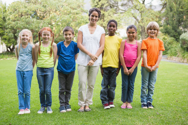 istock Pretty teacher standing with pupils outside 819321072