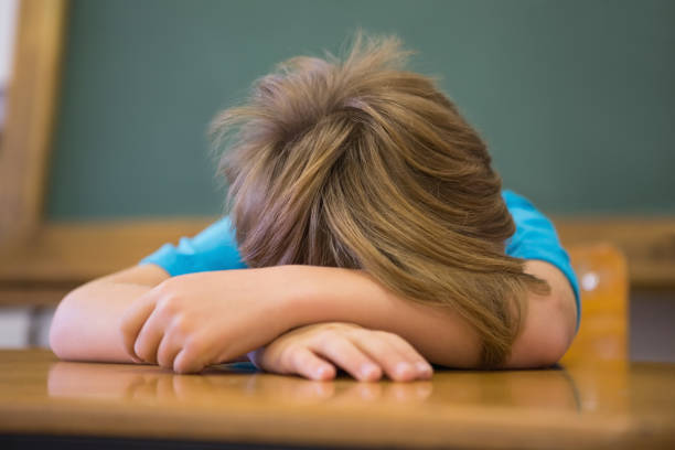 istock Sleepy pupil napping at desk in classroom 819330384