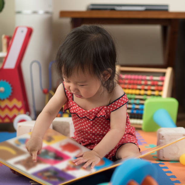 istock cute baby girl reading book 819339796