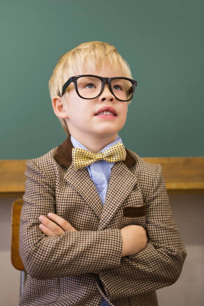 istock Cute pupil dressed up as teacher in classroom 819352076
