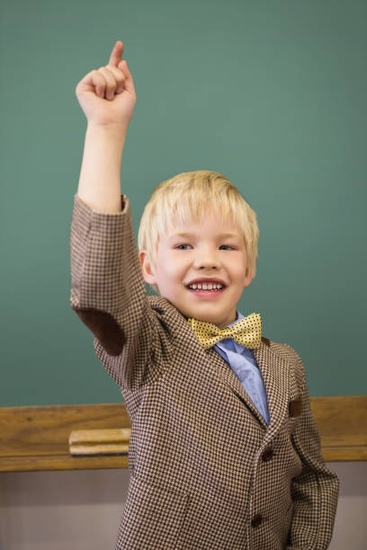 istock Cute pupil dressed up as teacher in classroom 819352110