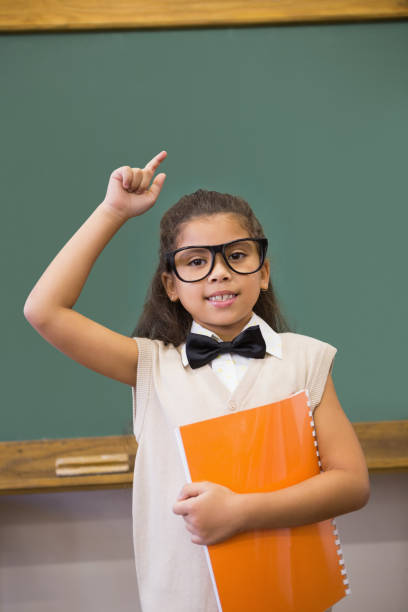istock Cute pupil dressed up as teacher in classroom 819352172