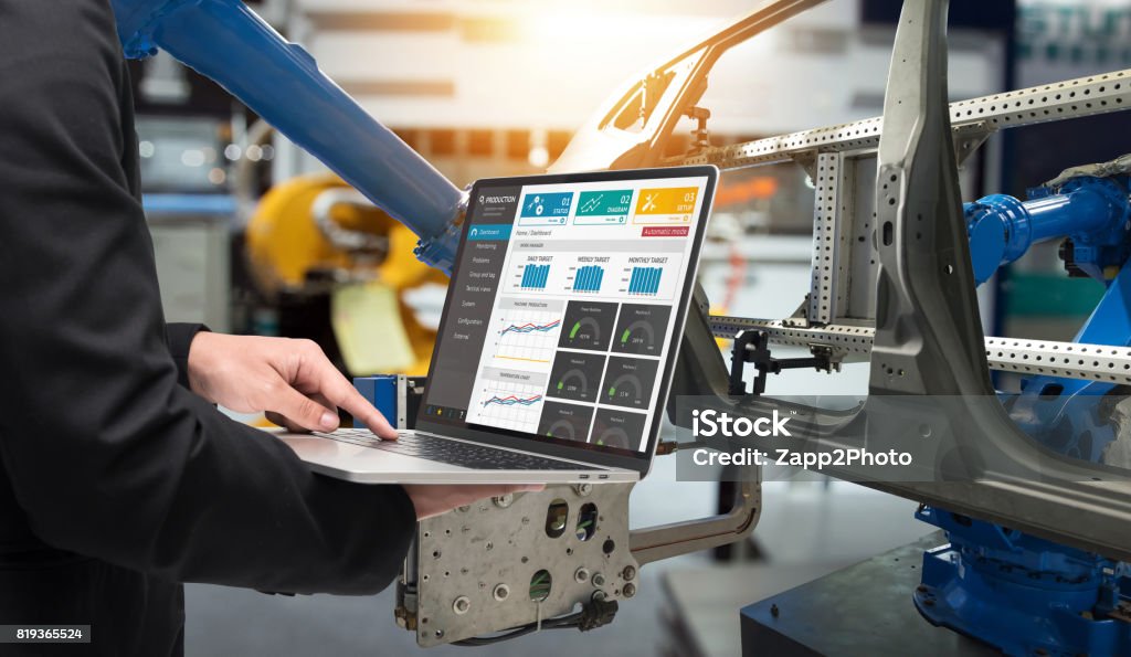 Male manager hand laptop for check real time production monitoring system application in smart factory industrial. Automated conveyor systems for package transfer machine Industry 4.0 and iot concept. Computer-Aided Manufacturing Stock Photo