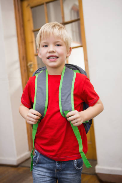 istock Cute pupil smiling at camera in classroom 819368490