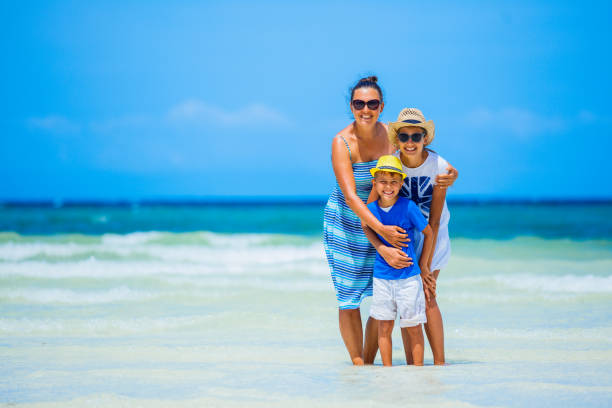 istock Mother with two kids at tropical beach 819373132