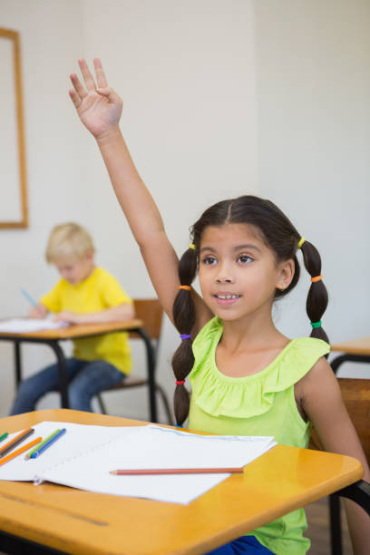 istock Cute pupils colouring at desks in classroom 819381984