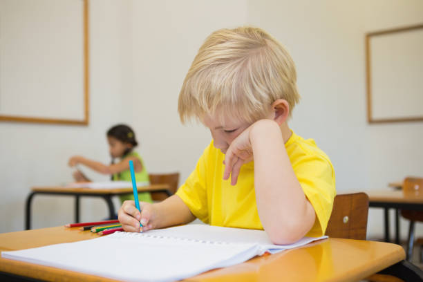 istock Cute pupils colouring at desks in classroom 819382038