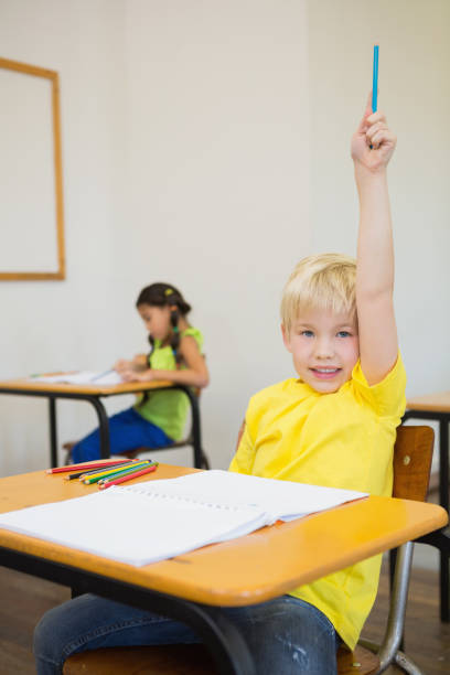 istock Cute pupils colouring at desks in classroom 819382080