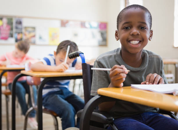 istock Disabled pupil smiling at camera in classroom 819382476