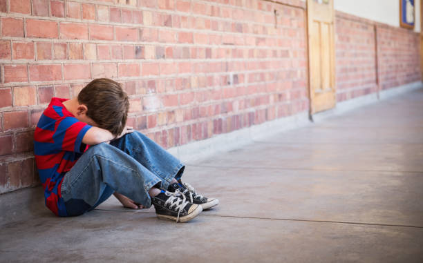 istock Sad pupil sitting alone in corridor 819400196