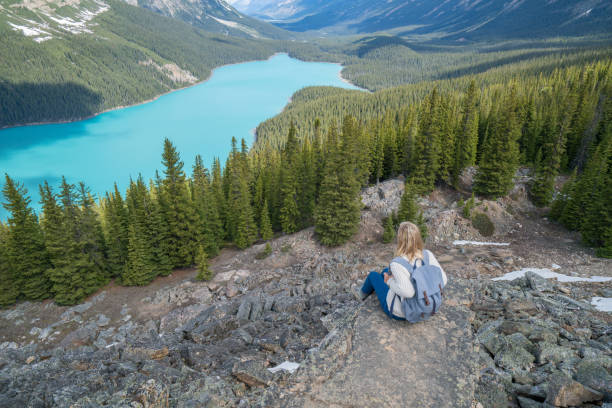 istock Female hiker sitting on last rock above blue lake 819405500
