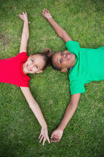 istock Cute children smiling at camera outside on the grass 819410418
