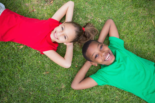 istock Cute children smiling at camera outside on the grass 819410444