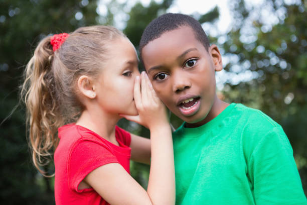 istock Cute children sharing gossip outside 819410558