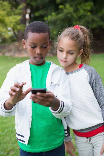 istock Cute little children looking at smartphone 819410656