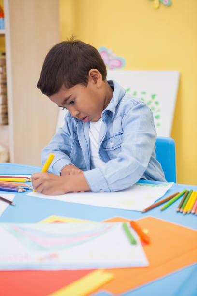 istock Cute little boy drawing at desk 819415016