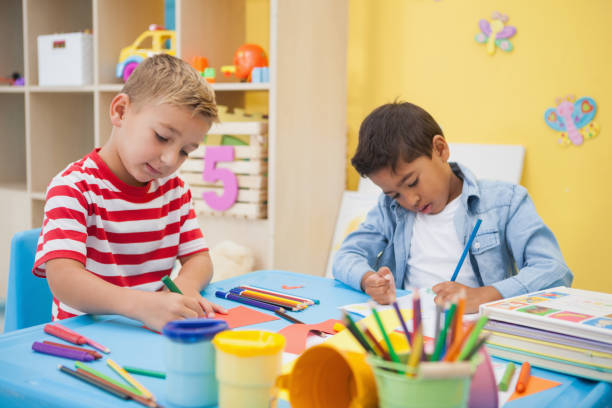 istock Cute little boys making art together in classroom 819424900