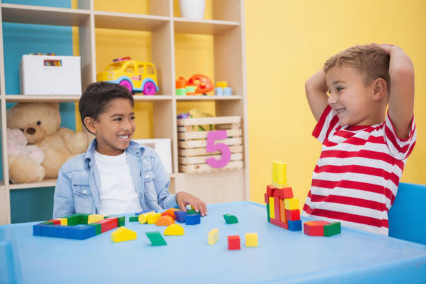 istock Cute little boys playing with building blocks 819425144
