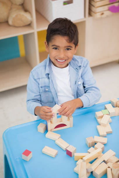 istock Cute little boy playing with building blocks 819425218