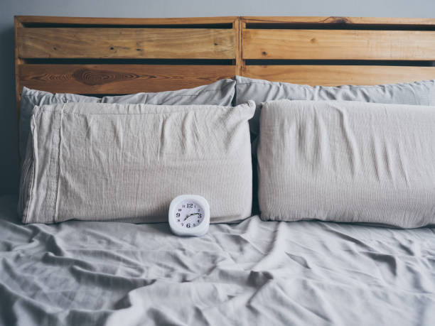 istock Clock on bed in the morning. 819425290