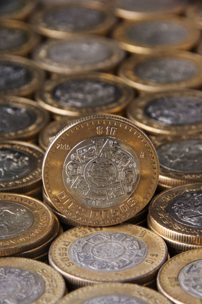 istock approach to Mexican 10 pesos coin on many aligned and applied coins 819445832