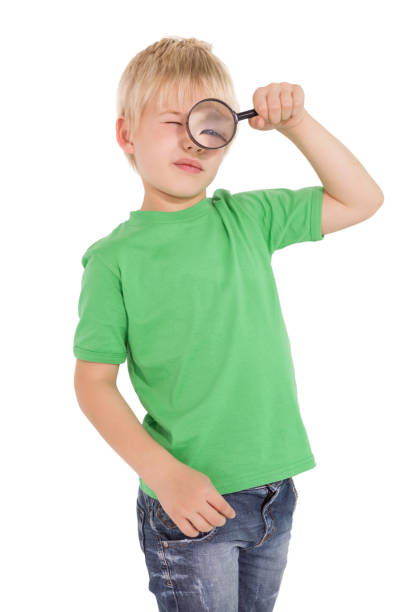 istock Cute little boy looking through magnifying glass 819456720
