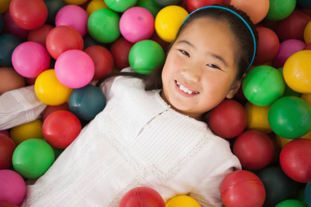 istock Happy girl playing in ball pool 819457188