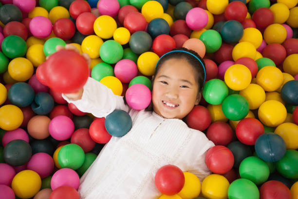 istock Happy girl playing in ball pool 819457534
