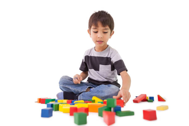 Happy little boy playing with building blocks on white background