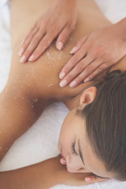 istock Beautiful brunette lying on massage table with salt scrub on back 819476516