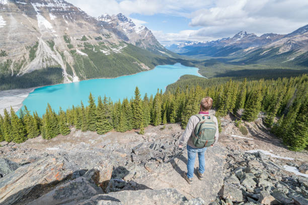 istock Young man hiker on rock above mountain lake 819479410
