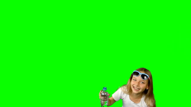 Little girl falls from laughing. Girl laughs and holds a bottle of water in her hands. Girl in sunglasses and a T-shirt. Clip contains solid green instead alpha channel.