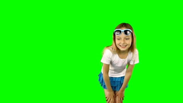 Little girl is showing her finger and dancing.. Girl in sunglasses and a T-shirt. Clip contains solid green instead alpha channel.