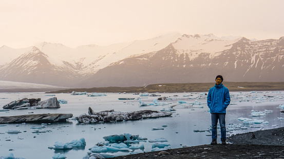 Asian traveler man standing in front of majestic beautiful landscape glacier lagoon of Iceland
