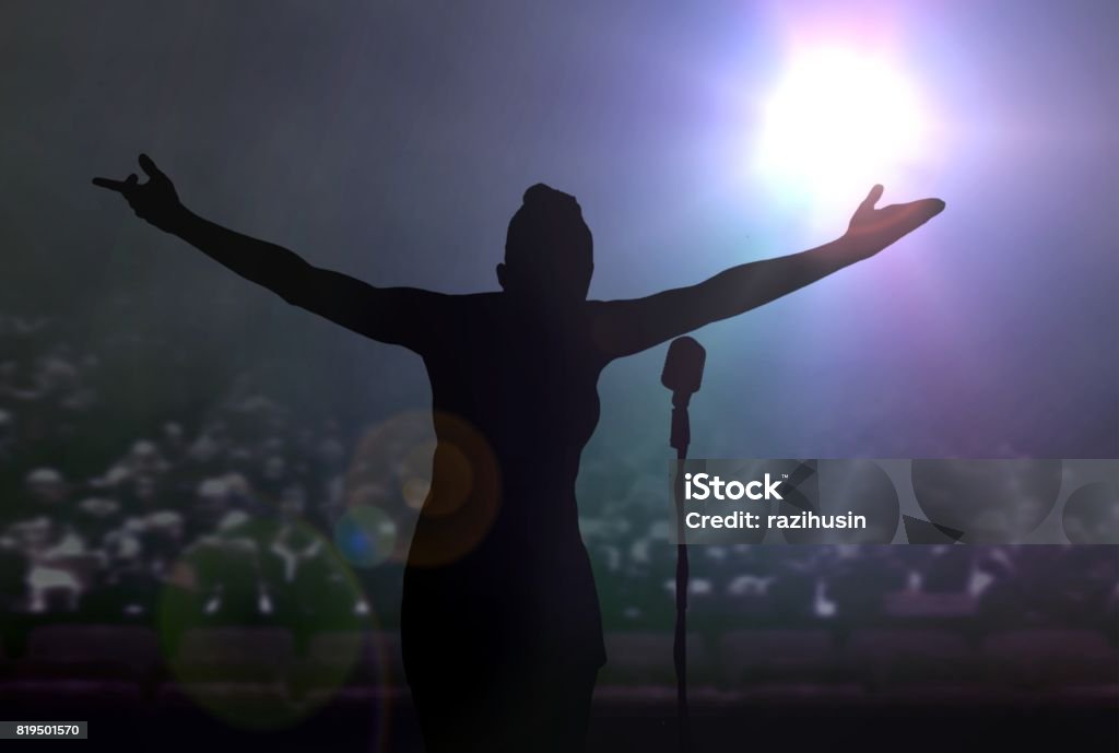 Women bowing on stage after a concert Women bowing on stage after a concert under bright spotlights Stage - Performance Space Stock Photo