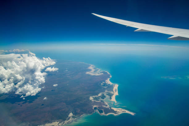 les nuages et le ciel comme on le voit par la fenêtre d’un avion. voler au-dessus de l’extrémité supérieure de l’australie, état du northern territory of australia. - arafura sea photos et images de collection