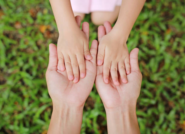 istock mother and daughter hands. 819521378
