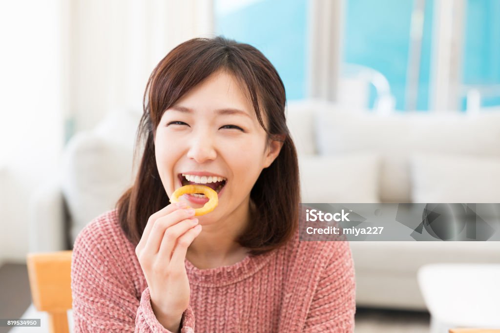 woman who eats young attractive asian woman who eats Snack Stock Photo