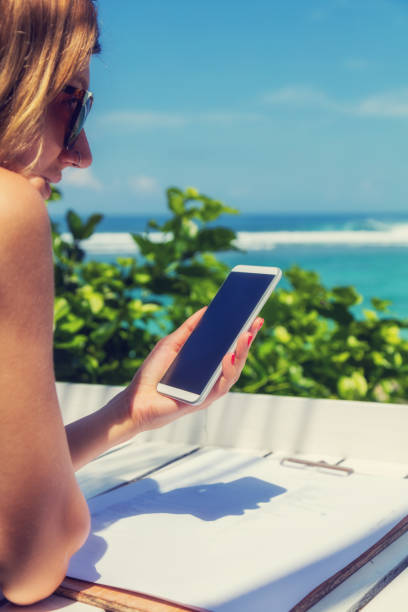 Girl using cellphone in the coffee shop on a tropical exotic beach. Girl using cellphone in the coffee shop on a tropical exotic beach. german free democratic party photos stock pictures, royalty-free photos & images