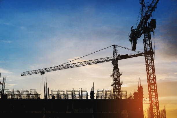 istock Silhouette building construction site with cranes in sunset 819556286