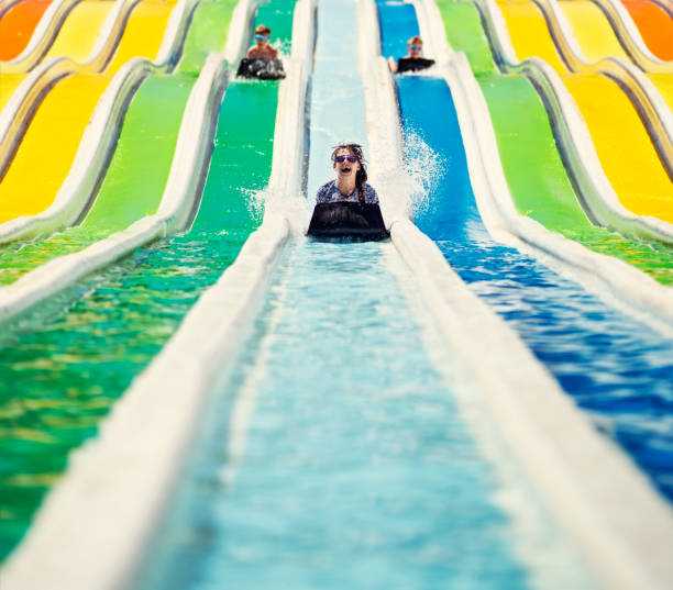 três crianças se divertindo em um parque aquático de deslizamento - lying on front joy enjoyment happiness - fotografias e filmes do acervo